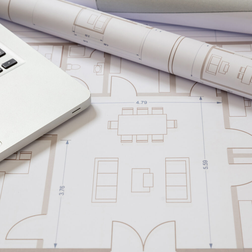Architect engineer office desk. Residential building project blueprints and computer laptop, copy space. Digital drawings and design
