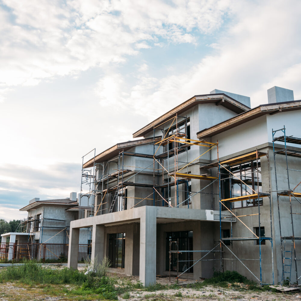 contemporary building construction with scaffolding under cloudy sky