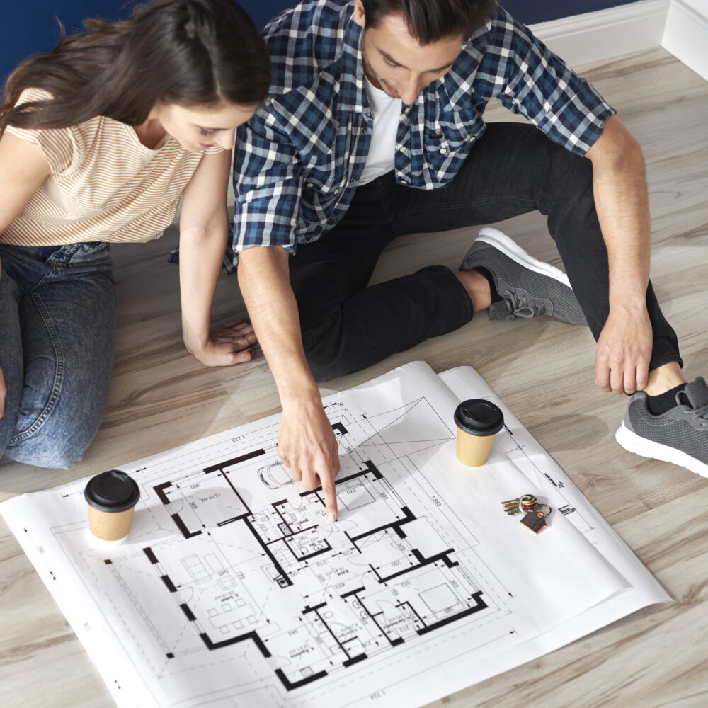 Couple looking at blueprint in new house