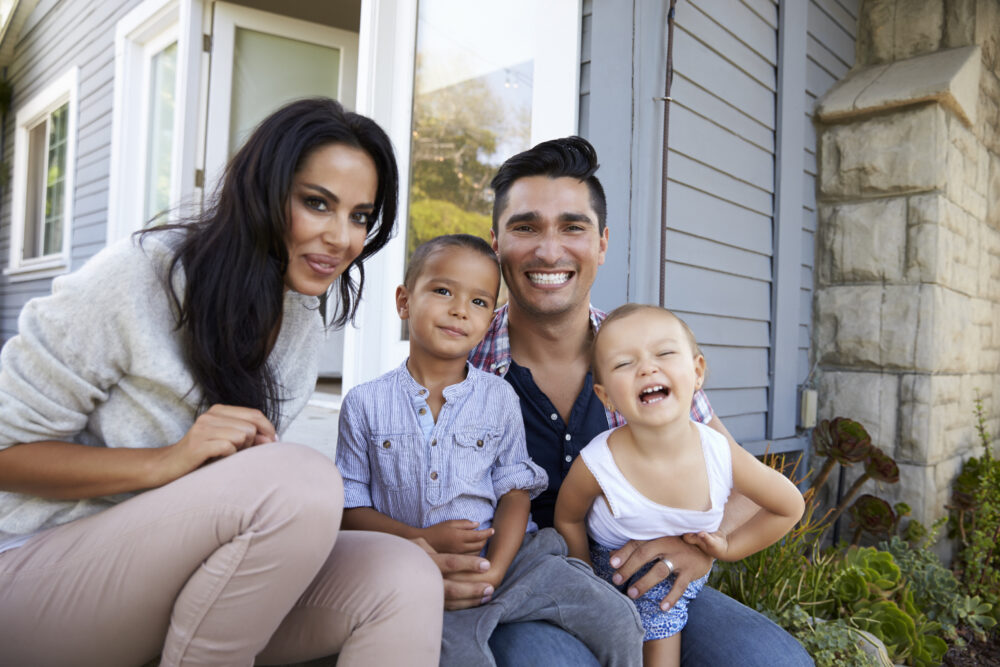Portrait Of Family Sitting On Steps Outside Home